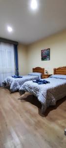 sypialnia z 2 łóżkami w pokoju w obiekcie Hostal Hotel EL Chato w mieście El Barraco