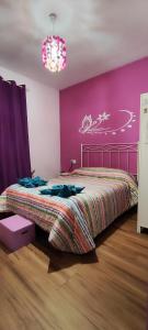 1 dormitorio con cama y pared de color rosa en Hostal Hotel EL Chato en El Barraco