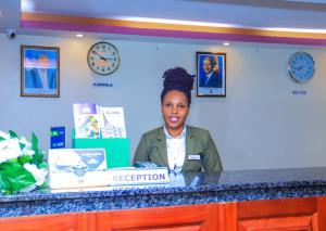 a woman sitting at a reception desk in a room at G-ONE HOTEL in Kampala