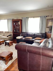 - un salon avec un canapé en cuir et une table dans l'établissement Ibanya Havens, 