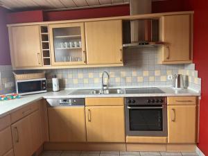 a kitchen with wooden cabinets and a sink at Ferienwohnung Aischgrund in Hallerndorf