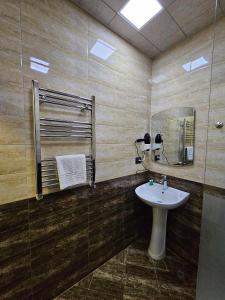 a bathroom with a sink and a mirror at Cityland Hotel Baku in Baku