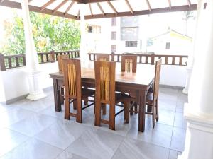 una mesa de comedor de madera y sillas en un porche en Villa 76, en Weligama