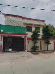 a building with a green awning and a garage at Karachi Family Guest House in Karachi