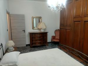 um quarto com uma cama, um espelho e uma cómoda em Casa Salosteli em Carcare