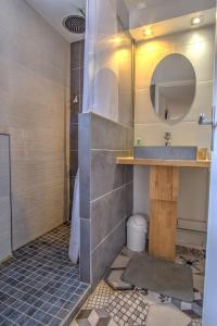 La salle de bains est pourvue d'un lavabo et d'un miroir. dans l'établissement Chalet au calme au milieu de la forêt., à Gujan-Mestras