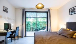 - une chambre avec un lit, un bureau et une fenêtre dans l'établissement Le Beau séjour, à Montpellier