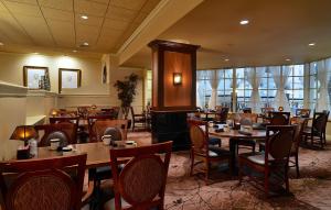 Eden Resort and Suites, BW Premier Collection في لانكستر: مطعم فيه طاولات وكراسي في الغرفة