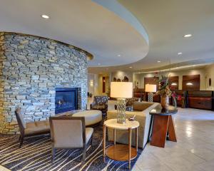 a living room with a stone wall and a fireplace at Eden Resort and Suites, BW Premier Collection in Lancaster