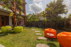 a yard with some chairs and a pathway at Candra Loka Studio & Apartment by The Loka in Kerobokan