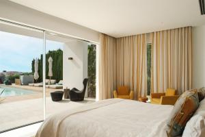um quarto com uma cama grande e uma piscina em Villa Sophie - Luxury Style & Sunset View em Sant Josep de sa Talaia