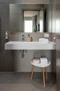 La salle de bains est pourvue d'un lavabo blanc et d'un miroir. dans l'établissement Marino1958 RTA, à Numana