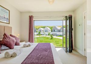 a bedroom with a bed with a large window at Kieton Sands - Croyde in Croyde