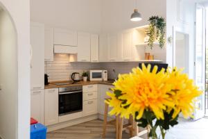kuchnia z białymi szafkami i żółtym kwiatem w obiekcie Mezzofanti - TRE PONTI w Mediolanie