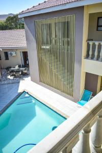 uma piscina com uma cerca ao lado de uma casa em Protea Guesthouse em Newcastle