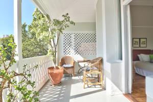 a porch with a potted plant and a bed at The Cape Colonial Guest House in Cape Town +71 photos