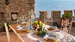 uma mesa com pratos e copos em cima em TORRE GRIMALDI 2&2, Emma Villas em Ventimiglia
