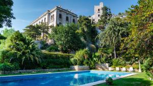 uma piscina num jardim com um edifício ao fundo em TORRE GRIMALDI 2&2, Emma Villas em Ventimiglia