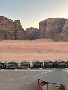 um grupo de tendas num deserto com montanhas em Mountain Magic Camp Wadi Rum em Wadi Rum