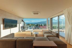 a living room with a couch and a large window at asoha in Minami Aso