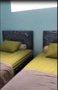 two beds sitting next to each other in a room at Bito Homestay 