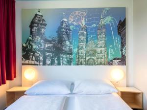 1 dormitorio con 2 camas y un cuadro en la pared en B&B Hotel Nürnberg-City, en Núremberg