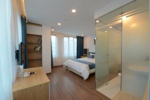 una camera con un letto e un grande specchio di Hanoi Prime Garden Hotel & Spa a Hanoi