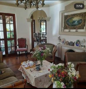 un soggiorno con tavolo e fiori di Royal Wattles a Nuwara Eliya