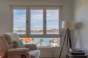 ein Wohnzimmer mit einem Stuhl und einem großen Fenster in der Unterkunft Bilbao Port by Aston Rentals in Santurce