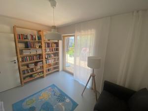 uma sala de estar com uma estante de livros e uma janela em Das Lavendelhaus em Weißenstadt