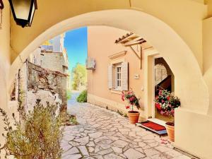 an archway of a building with flowers in a courtyard at Luxury Villa Azur Natura with private pool by DadoVillas in Spartýlas