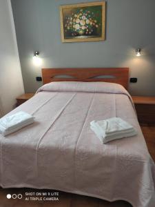 a bedroom with a bed with two white towels on it at Da Francesca in Scardovari