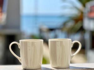 zwei weiße Kaffeetassen auf einem Tisch in der Unterkunft Cord Hotel & Resort in Edremit