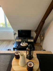 ein Wohnzimmer mit einem Tisch und einem TV in der Unterkunft L'Hellébore - Centre ville de Rennes in Rennes