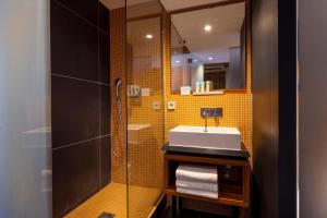 a bathroom with a sink and a shower at Hôtel Elixir in Paris