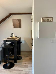 eine Küche mit einem Tisch und einem Kühlschrank in der Unterkunft L'Hellébore - Centre ville de Rennes in Rennes