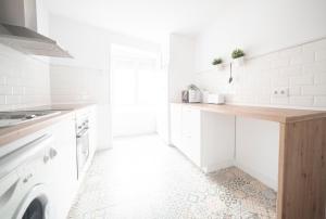 a white kitchen with a sink and a washing machine at Apartamento Balbín IV in Gijón +23 photos