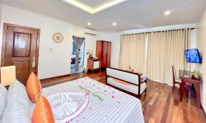 a living room with a bed and a television in it at Indra Angkor Residence in Siem Reap