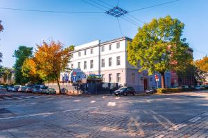 a large white building with cars parked on a street at Sztuka Smaku - Restauracja i Hotelik in Świdnica