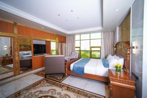 sypialnia z łóżkiem, biurkiem i telewizorem w obiekcie AG Hotel w Abu Zabi