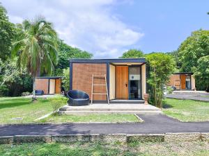 a tiny house with a staircase in a yard at Cala Laiya in San Juan