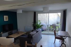 ein Wohnzimmer mit einem Sofa und einem Tisch in der Unterkunft L'inattendue - Maison centre ville - Dourdan in Dourdan
