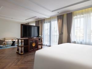 a hotel room with a bed and a flat screen tv at L'Signature Hotel & Spa in Hanoi