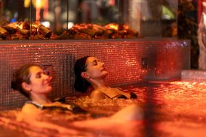 two women sitting in a bath tub with food at Säröhus Hotel, Conference & Spa in Särö