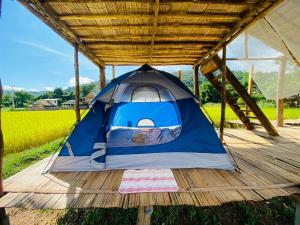 uma tenda azul e prateada num deque de madeira em PANAKLUEA Cottage & Crafts - พนาเกลือ 