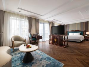 um quarto de hotel com uma cama e uma televisão em L'Signature Hotel & Spa em Hanói