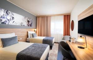 Posteľ alebo postele v izbe v ubytovaní Leonardo Hotel Vienna Hauptbahnhof