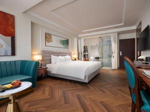 L'Signature Hotel & Spa في هانوي: غرفة فندقية بسرير وطاولة وكراسي