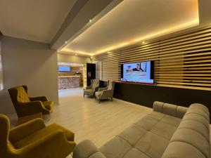 sala de estar con sofá y TV de pantalla plana en Cord Hotel & Resort, en Edremit