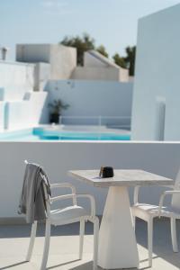 a table and chairs in front of a pool at White Concept Caves in Fira